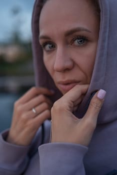 Woman sitting on the pier, closeup portrait, summer sunset