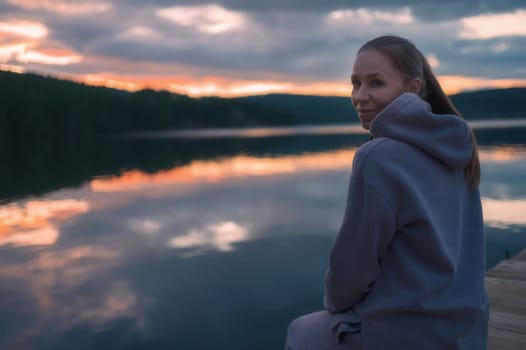 Woman sitting on the pier, closeup portrait, beauty summer sunset