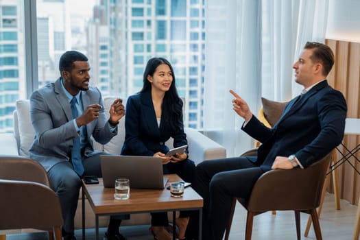 African businessman present start up project to expert investor. Group of multicultural business team solving problems, discussing business idea with skyscraper at modern business lounge. Ornamented