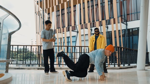 Hip hop team dance break dance while multicultural friend surrounded and clapping hands to cheer or encourage his friend to dance. Active and energetic street dance. Outdoor sport 2024. Endeavor.