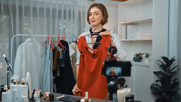 Woman influencer shoot live streaming vlog video review clothes prim social media or blog. Happy young girl with apparel studio lighting for marketing recording session broadcasting online.