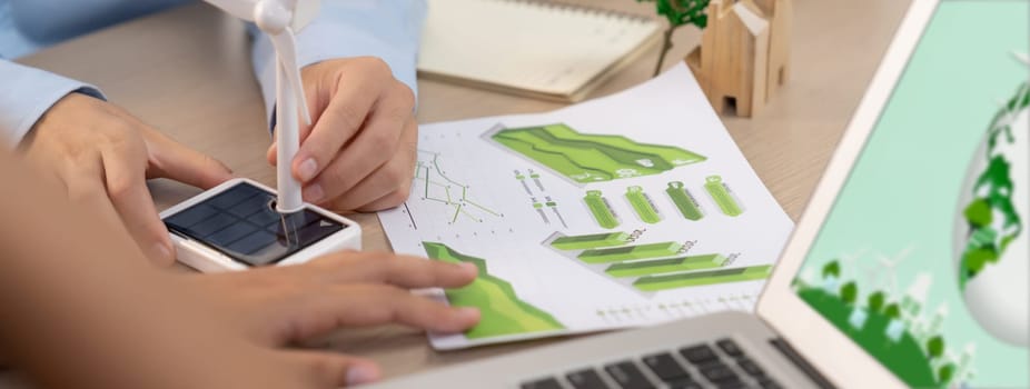 The graph shows the result of using renewable energy increase profit was placed on the table with windmill model represented using renewable energy. Environmental friendly concept. Delineation.