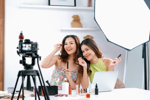 Asian Woman influencer shoot live streaming vlog video review makeup uttermost social media or blog. Happy young girl with cosmetics studio lighting for marketing recording session broadcasting online