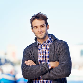 Smile, crossed arms and portrait of man at harbor on travel for vacation, adventure or holiday. Happy, outdoor and confident person by sea port on weekend trip in Cape Town with positive attitude