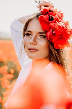 Woman poppies field. Side view of a happy woman with long hair in a poppy field and enjoying the beauty of nature in a warm summer day