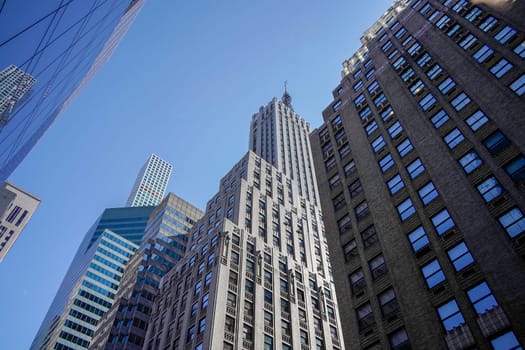 new york city manhattan skyscrapers view from the street to the top of the building on sunny clear day