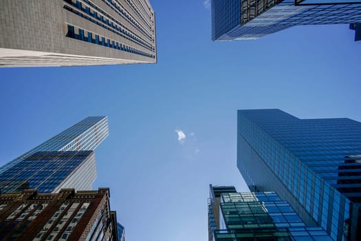 new york city manhattan skyscrapers view from the street to the top of the building on sunny clear day