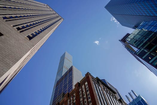 new york city manhattan skyscrapers view from the street to the top of the building on sunny clear day