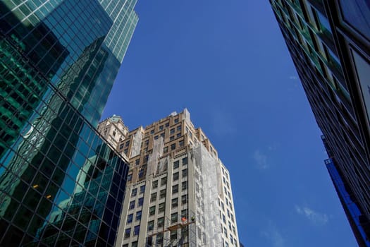 new york city manhattan skyscrapers view from the street to the top of the building on sunny clear day