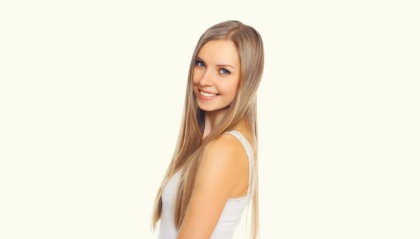 Portrait of beautiful blonde smiling young woman with long hair on white studio background