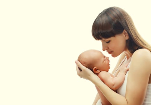 Happy young mother holding cute infant, baby sleeping in arms on white studio background
