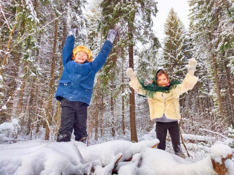 Two cute happy little cheerful children walking and having fun in winter snow forest. Photo shoot in stylized clothes of the USSR. Fur Hat with earflaps