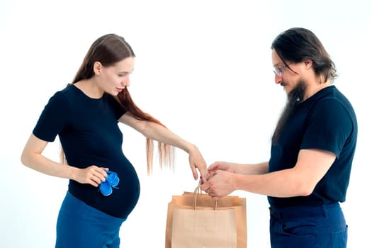 Portrait happy young pregnant woman and her husband with shopping bags and touching her big belly isolated on white background. Pregnancy shopping concept happy young family with shopping bags