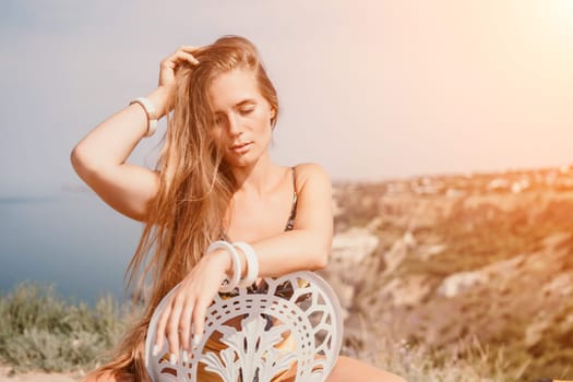 Happy woman portrait in cafe. Boho chic fashion style. Outdoor photo of young happy woman with long hair, sunny weather outdoors sitting in modern cafe