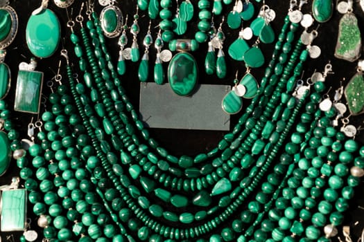 Malachite necklage earrings jewelry on display stand in a shop market detail