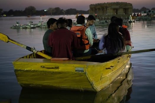 Jaisalmer, Rajasthan, India - 29th Dec 2023: People enjoying boating with their family on the golden waters of Gadisar lake in Jaisalmer Rajasthan India