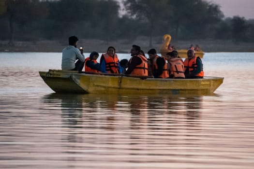 Jaisalmer, Rajasthan, India - 29th Dec 2023: People enjoying boating with their family on the golden waters of Gadisar lake in Jaisalmer Rajasthan India