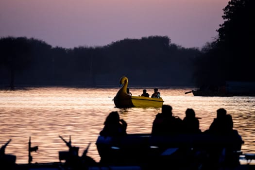 Jaisalmer, Rajasthan, India - 29th Dec 2023: People enjoying boating with their family on the golden waters of Gadisar lake in Jaisalmer Rajasthan India