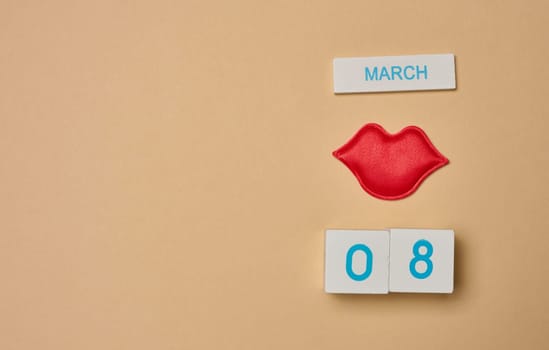 Textile red lips and cubes with the inscription March 8th, International Women's Day. View from above