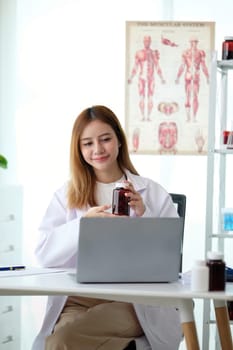 Young woman asia doctor with stethoscope using computer laptop talking video conference call with patient at desk in health clinic or hospital. Consulting and therapy concept.