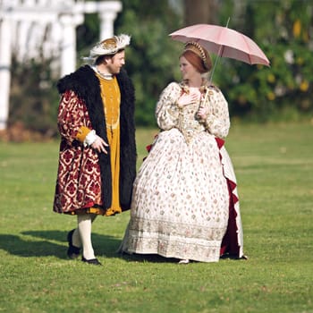Medieval, walking and couple in history with renaissance fashion outdoor with marriage and love. Vintage, garden and royal leader with queen together on a lawn with conversation and theater costume.