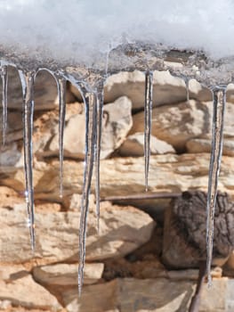 icicle on stone wall in winter time