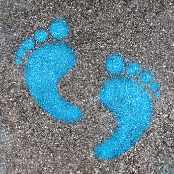 Blue footprint signs on an asphalt road for pedestrian. Symbol of walkway.