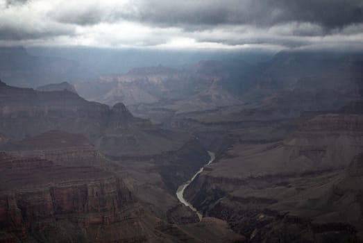 Passing rain storm produces clouds that filter the sunlight at Grand Canyon National Park, Arizona