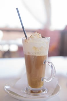 coffee is served in a tall glass glass with a straw. The concept of coffee drinks from the bar menu.