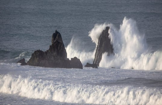 Powerful waves crash upon the beach alog the Pacific Ocean at Big Sur, Californias