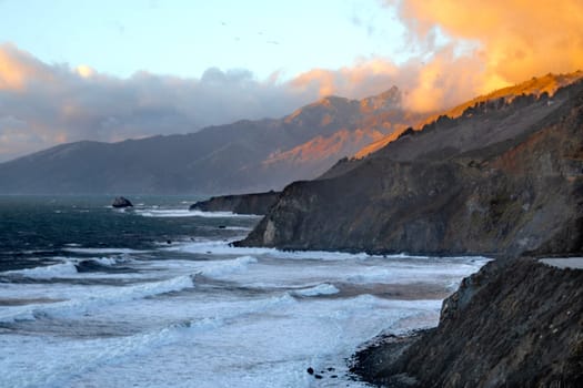 Powerful waves crash upon the beach alog the Pacific Ocean at Big Sur, Californias