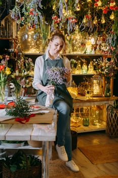 A woman in her florist shop collects bouquets of flowers. The concept of a small business. Bouquets of tulips for the holiday on March 8