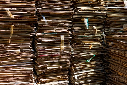 Stacks of crushed cardboard boxes, piled on top of each other, full-frame closeup background.