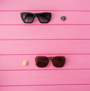 Summer abstract background mockup template free copy space for text pattern sample top view above on pink wooden board. blank empty area for inscription. Stylish sunglasses fashionable with seashells