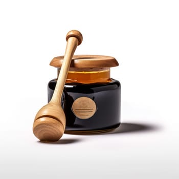 A wooden spoon is next to a jar of honey. The spoon is made of wood and has a curved handle. The jar of honey is in a glass container and is sitting on a white background