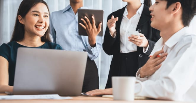 Happy diverse business people work together, discussing in corporate office. Professional and diversity teamwork discuss business plan on desk with laptop. Modern multicultural office worker. Concord