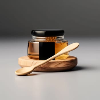 A wooden spoon is next to a jar of honey. The spoon is made of wood and has a curved handle. The jar of honey is in a glass container and is sitting on a white background