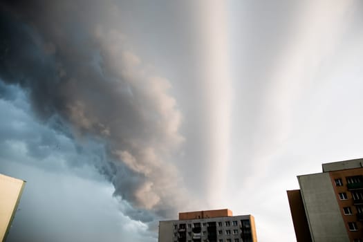 A local hurricane rages over city skyscrapers. The sky is covered with clouds.