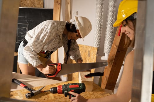 You will give joy to work on a construction site. Two young girls, a blonde and a brunette, happily work inside the shed.