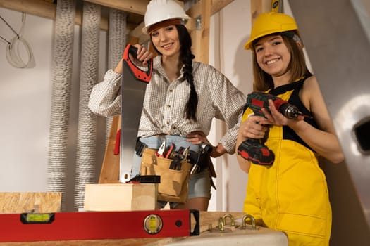 A brunette with a braid and a blonde with short hair are waiting for the start of a new job on the construction site.