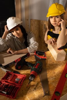 Two young adults tired of hard work building a mezzanine. Take a break before the next task.