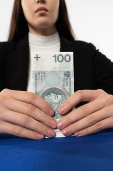 Young adult sitting at the table with money in hand. The ban employee is waiting for the customer who ordered the burn from his account.