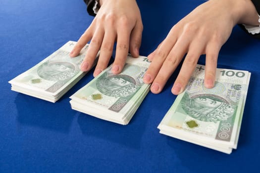 Banknotes neatly placed on a blue tablecloth are waiting for the person who decides to take out a cash loan.