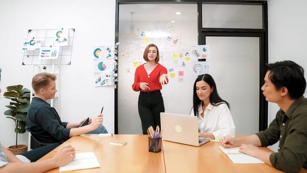 Young beautiful leader presents marketing strategy while expert investor and project manager listening and lecturing to analyze business performance at start up business meeting. Immaculate.