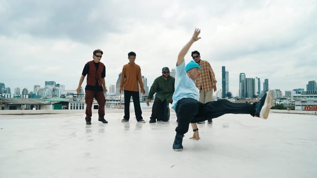 Professional break dance team practice B-boy dance while multicultural friends at rooftop. Young modern dancing group doing hip hop movement. Style,fashion,action. Outdoor sport 2024. Endeavor.