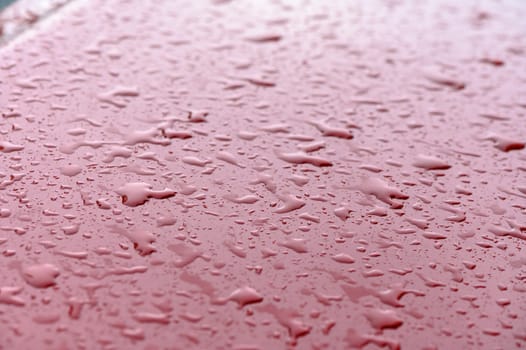 Closeup rain drops on red car 1