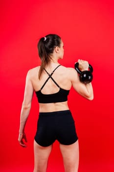 Young female doing swing exercise with kettle bell. Fitness woman