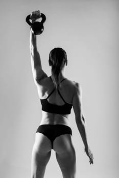 Young female doing swing exercise with kettle bell. Fitness woman