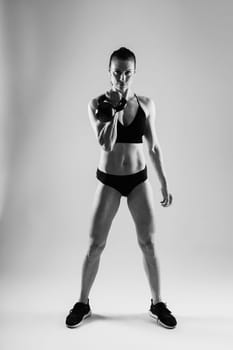 Young female doing swing exercise with kettle bell. Fitness woman