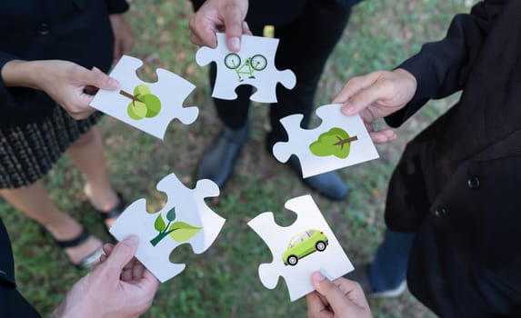 Business people or corporate partnership joining ECO friendly idea puzzle of jigsaw together as group of eco professional teamwork concept to promote social awareness on environmental protection. Gyre